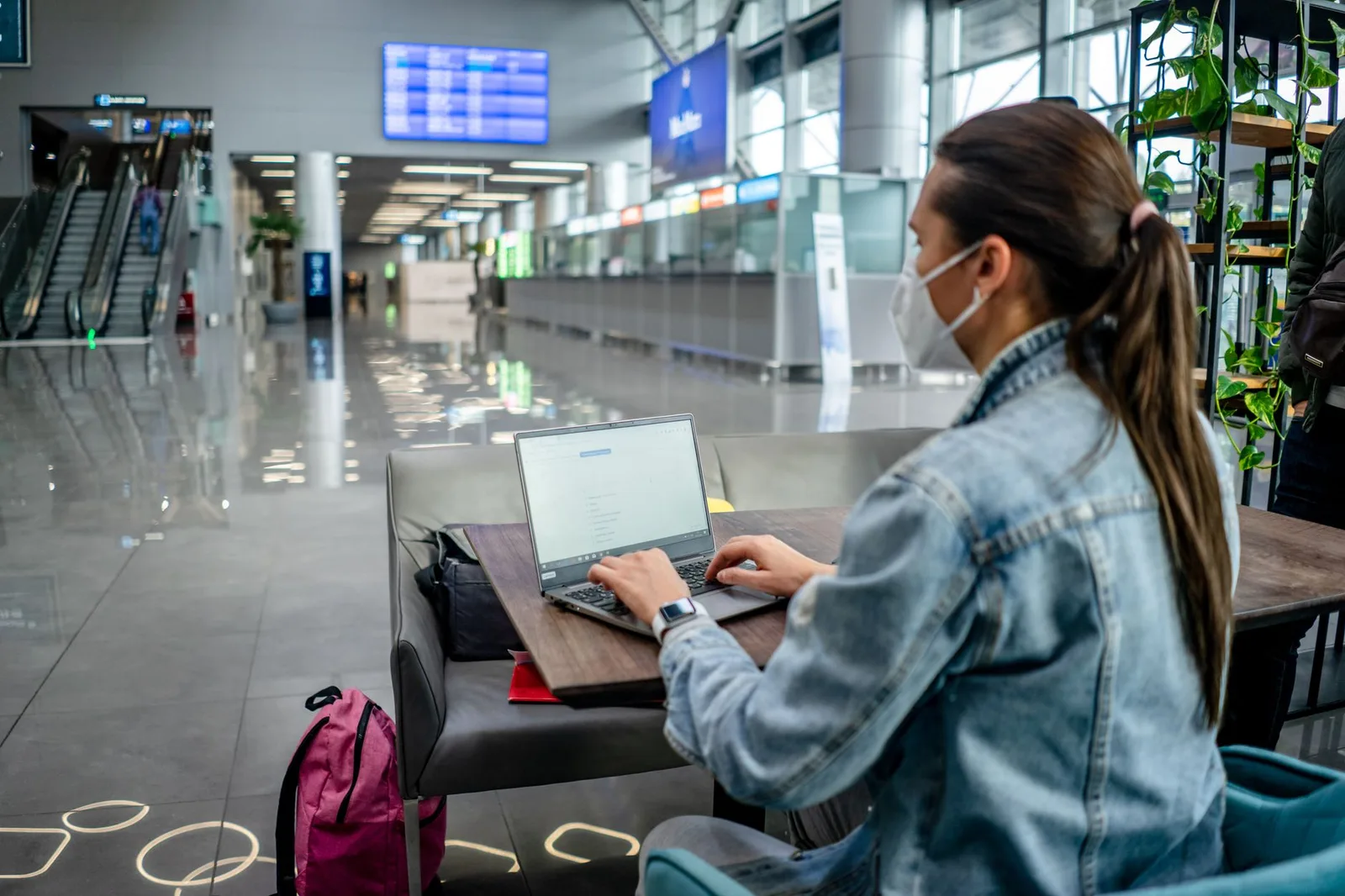 Voyageur comparant des prix sur un ordinateur à l’aéroport